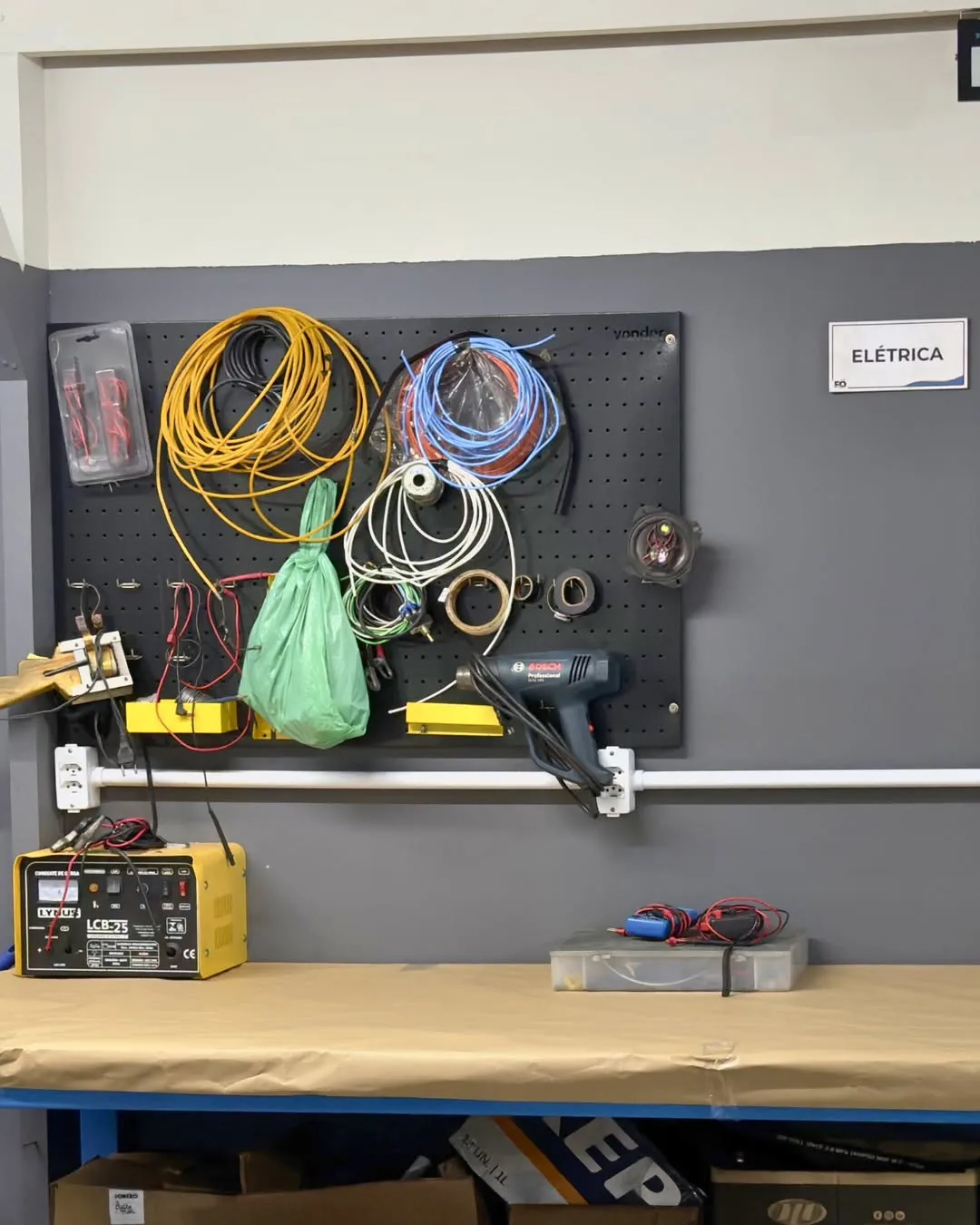 Bancada do setor de elétrica da oficina Förtro com cabos e equipamentos de teste